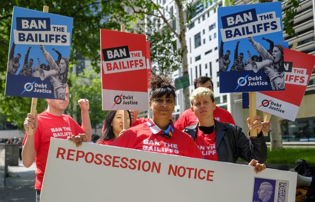 A group of people at a 'Ban the Bailiffs' process organised by Debt Justice