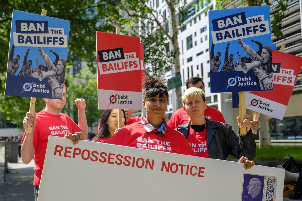 A group of people at a 'Ban the Bailiffs' process organised by Debt Justice
