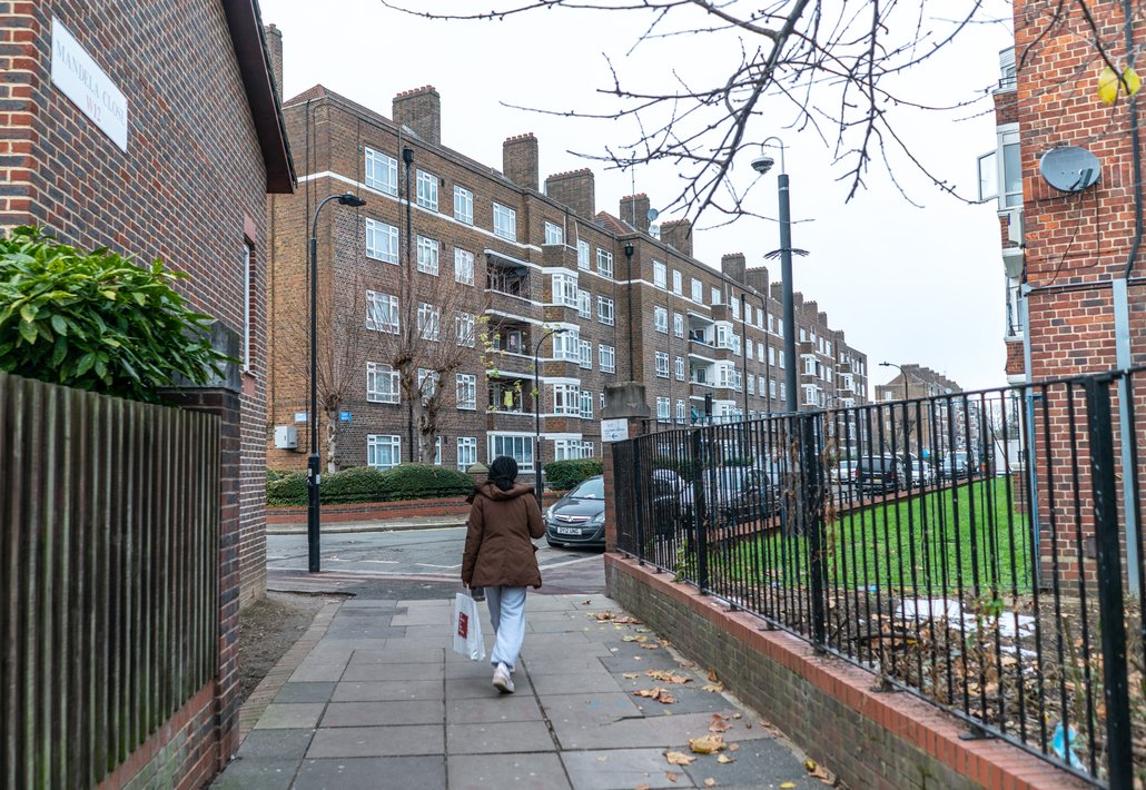 A woman walks through the White City Housing Estate